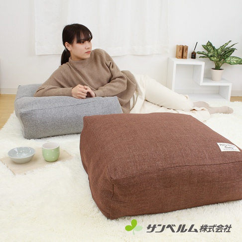 兩款多用途棉被收納袋，一款為灰色的長方形，另一款為棕色的方形，皆為棉麻材質，置於白色長毛地毯上，有細微紋理。