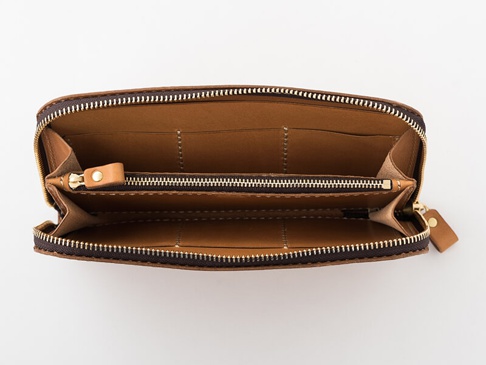 職人手作皮革長夾，深棕色皮革外觀，拉鍊開合，內部為淺棕色皮革，有數個卡槽及夾層，中間設有拉鍊零錢袋，拉鍊為金色。