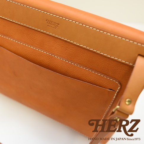 職人手作皮革經典郵差包 CK-4 M，採用天然皮革材質，呈現溫潤的棕色調。包款設計簡潔，表面有細緻的車縫線，並壓印有品牌標誌。