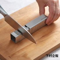 ESSYO 越匠系列可拆式不鏽鋼雙滾輪磨刀器，銀色不鏽鋼材質，搭配木質砧板，展示刀刃置於磨刀器中。