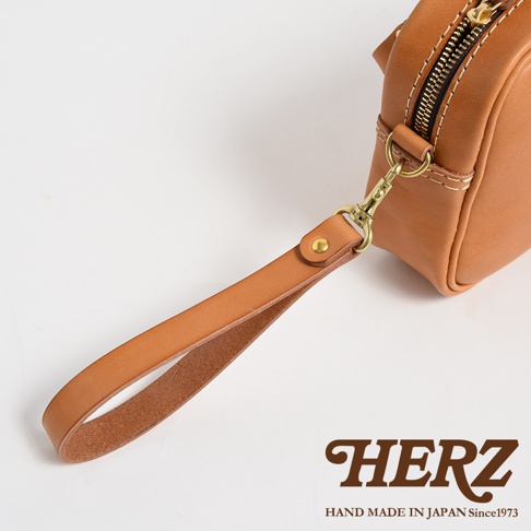 職人手作皮革可拆式扣環萬用手提包，採用淺棕色皮革，搭配金色金屬扣環和拉鍊，手提帶可拆卸。