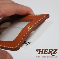 職人手作皮革直式證件識別夾，採用棕褐色皮革，縫線清晰，配有金色銅釦，可插入卡片。