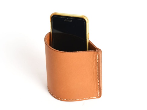 淺棕色皮革製成的筆筒，頂部開口，側面有縫線裝飾，一個手機置於其中。