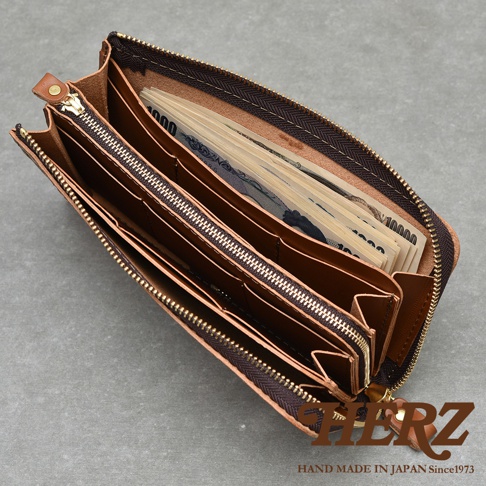職人手作皮革Organ拉鍊長夾，內有日圓鈔票，並有品牌HERZ字樣及HAND MADE IN JAPAN Since1973字樣。