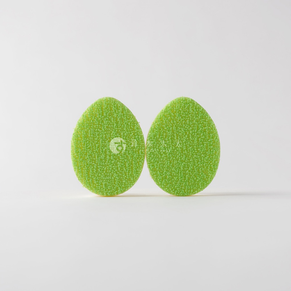 兩個橢圓形的綠色海綿，上面有細小的顆粒紋理，其中一個海綿上有一個圓形標誌和中英文字。