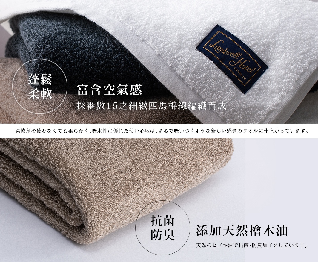 堆疊的泉州匹馬棉浴巾，有深藍色、棕褐色和白色，白色浴巾上帶有「Landwell Hotel」標籤。