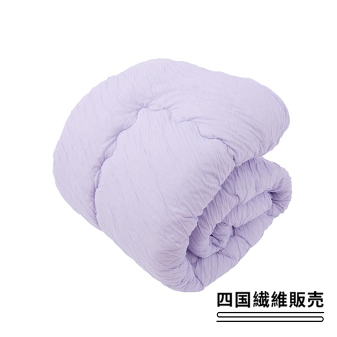 一床淺紫色、帶有舒芙蕾紋理的四季被，材質輕盈蓬鬆，中間棉填充，適合全年使用。