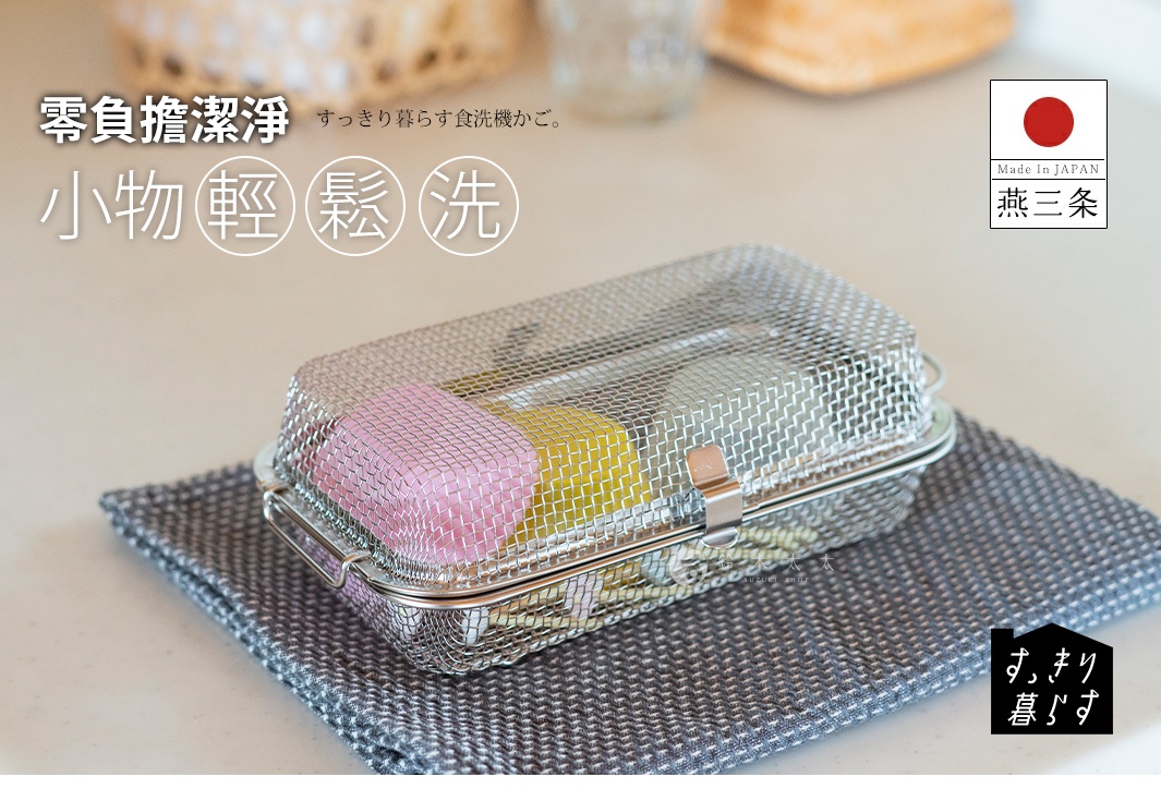 不鏽鋼網狀收納盒，內有粉紅色和黃色的物品，置於灰色織物上。