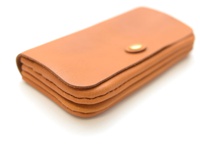 職人手作皮革旅行用長夾，呈現自然棕色皮革，設有金屬按扣，多層次結構，設計簡約。