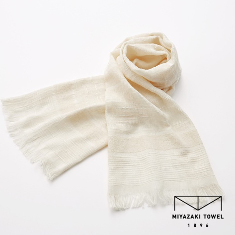 淺米色今治匹馬棉圍巾，質地輕柔，織紋細膩，兩端帶有流蘇，展現出經典優雅的風格。