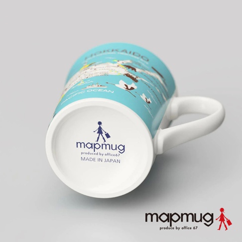 一個藍色馬克杯，印有北海道地圖圖案，包含太平洋和飛翔的鶴，杯底有mapmug品牌標誌和「MADE IN JAPAN」字樣。