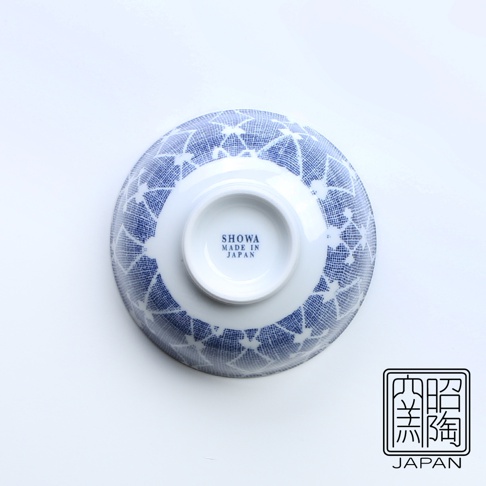 白底藍染的飯碗，碗身外側印有細膩的藍色菱形網紋圖案。碗底中央有白色圓形標識，印有「SHOWA MADE IN JAPAN」字樣。右下角為「照窯」日文漢字與「JAPAN」英文標誌。