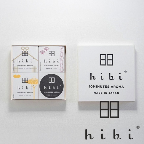 這是一組hibi香氛火柴禮盒的產品照，左側為打開的包裝盒，內含四個標示著hibi品牌字樣與和風圖案的小盒香氛，右側為白色方形外包裝盒，上方印有hibi品牌標誌及10MINUTES AROMA字樣。圖片下方並單獨展示了黑色的hibi品牌logo及其象徵性的窗框圖案。