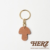 棕色皮革香菇造型鑰匙圈，搭配金色金屬鑰匙環與掛鉤，呈現簡約可愛的設計。