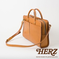 職人手作皮革雙口袋兩用商務公事包，淺棕色皮革，設有雙前口袋、拉鍊主隔層、頂部提把及可拆卸肩帶。