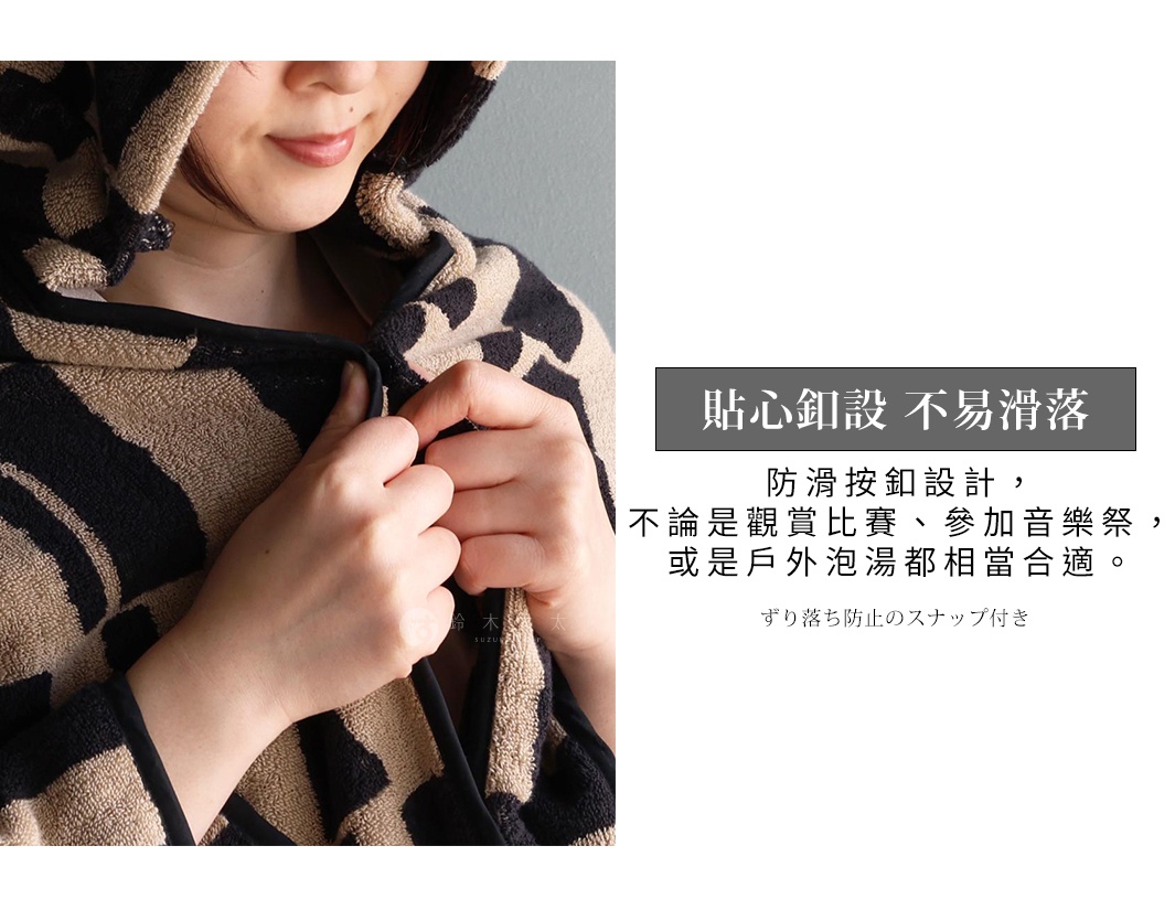 模特兒穿著格紋連帽浴巾，雙手正在扣上浴巾的按鈕，旁邊有日文和中文介紹其「貼心鈕設 不易滑落」，表示其防滑按鈕設計，適合觀賞比賽、參加音樂祭或泡戶外溫泉。