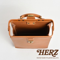 職人手作皮革杜勒斯商務後背包，展示棕色皮革材質，開啟的包蓋、金屬鎖扣及提把，內部空間清晰可見。