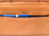 職人手作皮革屋瓦風兩用側背包 (CW-147) M，淺棕色皮革，正面有一個藍色圓點圖案的布料與一支黑色筆，皮革表面有細緻縫線，並壓印有「HERZ」品牌標誌。