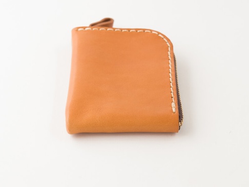 職人手作皮革分隔收納迷你錢包 (KK-2)，一個棕褐色皮革製成的 L 型拉鍊錢包，以白色縫線手工縫製，呈現簡約質感。