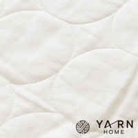 白色脫脂棉混紡材質廚房拭巾，表面有菱格紋縫線和圓形圖案縫線，右下角有「YARN HOME」品牌標誌。