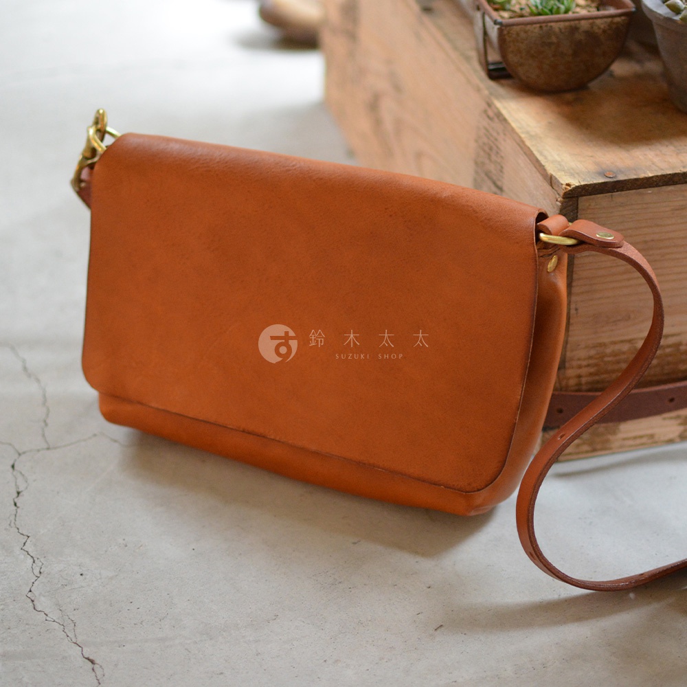 職人手作皮革Organ隨身斜背包，溫潤的棕色皮革，簡約的翻蓋設計，搭配金屬釦環與皮質背帶，呈現復古質感。