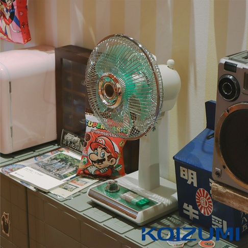 復古白色電風扇，金屬網罩，綠色扇葉，底座為白色，配有綠色與銀色按鈕。