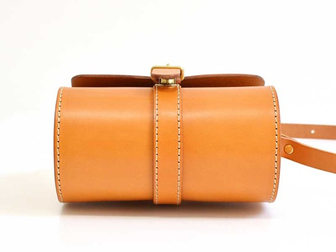 職人手作皮革皮扣單肩包 (CP-38)，淺棕色光滑皮革製成，圓筒形設計，搭配皮革束帶及金色金屬皮扣，精緻車縫線裝飾，簡約大方。