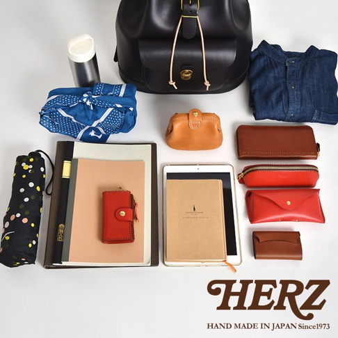 黑色皮革後背包、丹寧襯衫、藍色印花包巾、棕色皮革長夾、紅色皮革筆袋、紅色皮革信封包、棕色皮革名片夾、橘色皮革零錢包、黑色圓點雨傘、筆記本、平板電腦、紅色皮革鑰匙包。