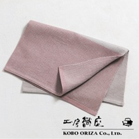 粉色與灰色雙色棉麻混紡拭巾，表面有鬆餅紋理，邊緣有粉色滾邊。