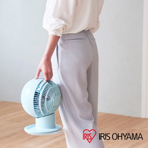 淺藍色圓形空氣循環扇，具有可調節底座和網狀風扇罩，由一位女士手持。