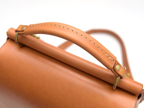 職人手作皮革屋瓦風兩用單肩包 (CW-3)，以淺棕色皮革製成，帶有精緻的縫線細節，頂部設有圓潤的提把，並以黃銅色金屬扣件固定。