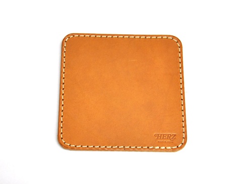 職人手作皮革印章墊板 (KZ-72)，淺棕色皮革，方形，四角圓潤，邊緣以白色縫線裝飾，右下方壓印有「HERZ」及「MADE IN JAPAN」字樣。