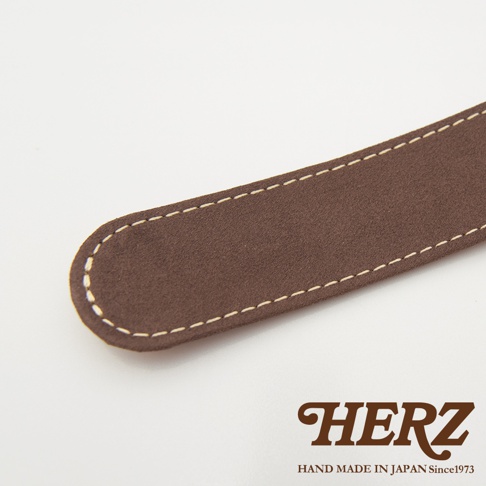 深棕色麂皮皮革肩墊，帶有米色縫線，邊緣圓潤，印有HERZ品牌標誌。