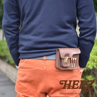 職人手作皮革高爾夫腰包，採用棕色皮革製成，設有翻蓋與金屬旋釦，可收納高爾夫球和球釘。