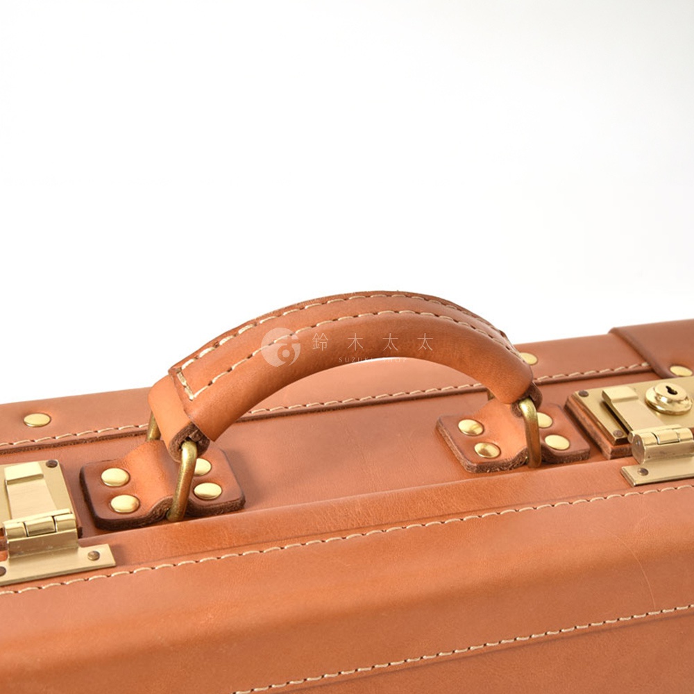 職人手作皮革英倫風便攜手提行李箱，採用棕色皮革材質，配有黃銅色五金鎖扣和手提把。精緻車縫線和簡潔設計，展現復古質感。