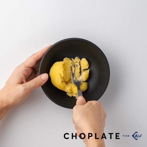 CHOPLATE BOWL沙拉碗，黑色，圓形，內部裝有被叉子壓碎的馬鈴薯。