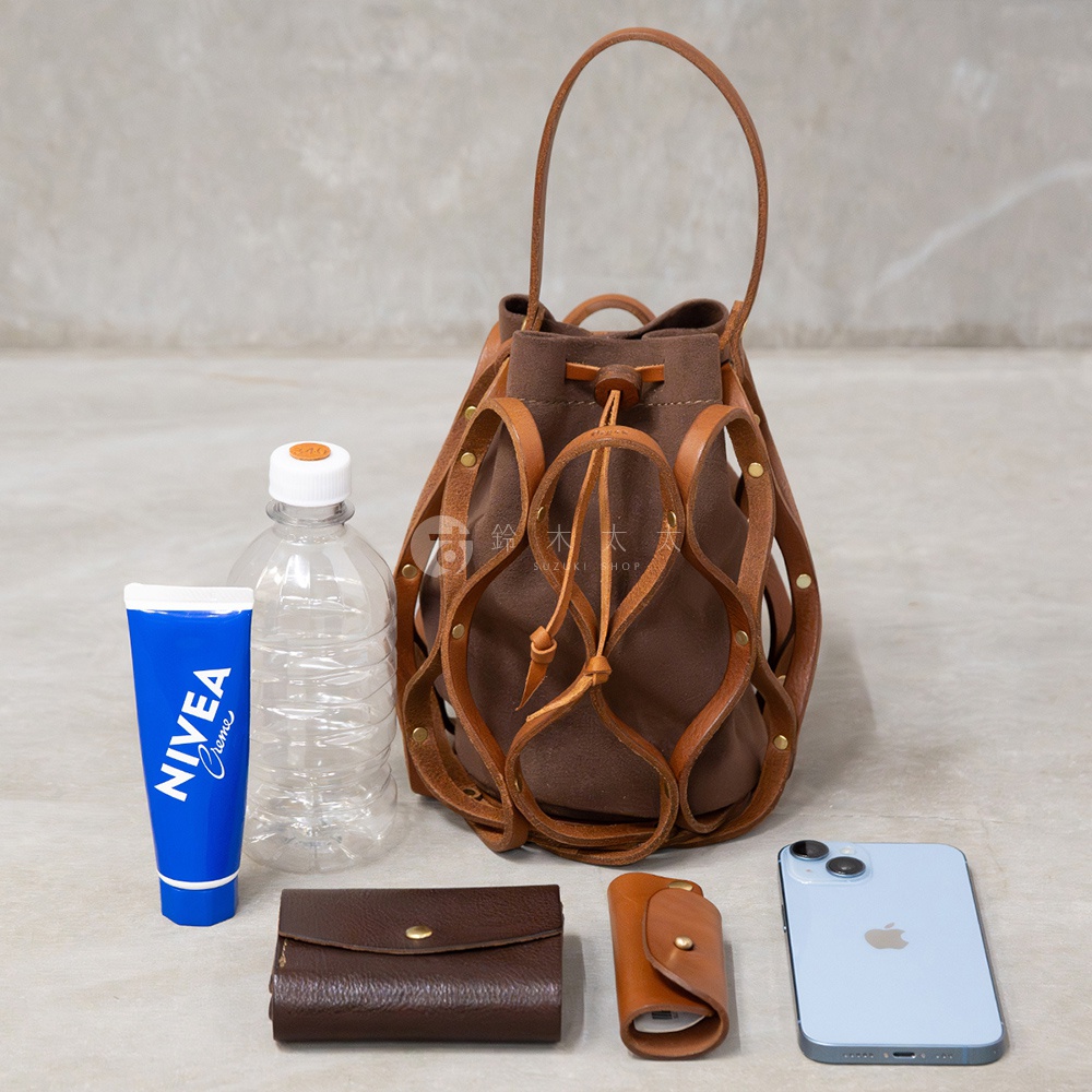 日本HERZ職人手作皮革Organ編織水桶包 G-98，搭配NIVEA護手霜、水壺、皮夾、鑰匙包和iPhone手機。