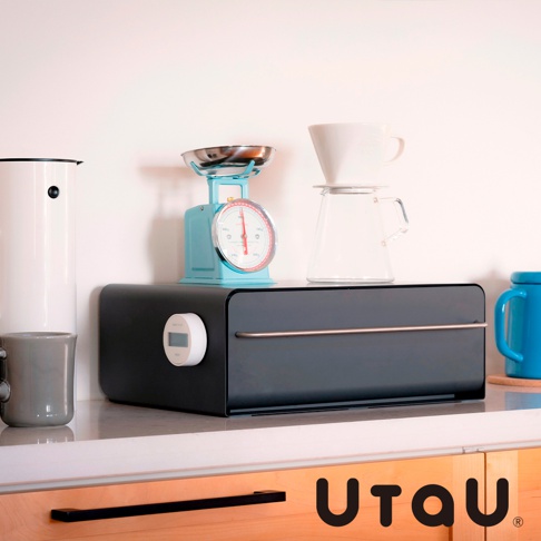 黑色抽屜式多功能萬用收納整理櫃，設有銀色金屬把手及一個白色圓形計時器，櫃上擺放著藍色復古磅秤、濾杯咖啡壺組及白色馬克杯。