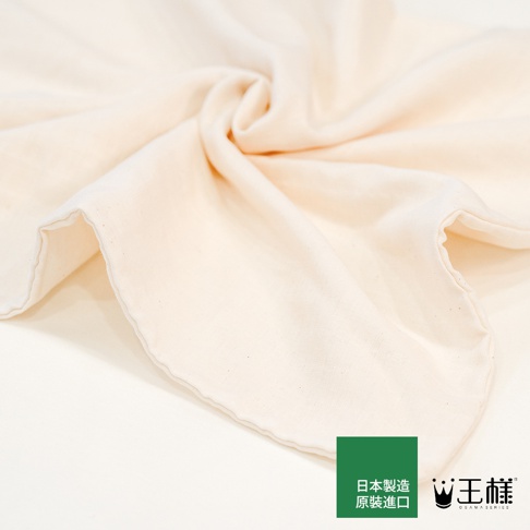 一張淺米色布料的特寫照片，布料呈現柔軟的皺褶，形成旋渦狀。右下角有綠色方塊，上面印有日文「日本製 原裝進口」的字樣，旁邊是「王樣」的品牌標誌，標誌下方印有「OSAMA SERIES」。