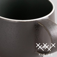 深灰色美濃燒珪晶釉球型馬克杯，帶有白色杯緣和一個弧形杯把，杯身表面有細微的斑點紋理。