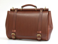 一個棕色皮革製成的兩用側背包，有手提把、兩條可調節的肩帶，配有黃銅色釦環和金屬環，風格簡約。