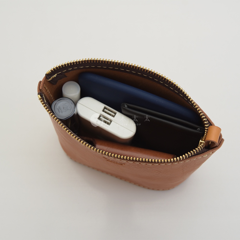 職人手作皮革三角收納包，淺棕色皮革，內有手機、充電寶、口紅及卡夾。