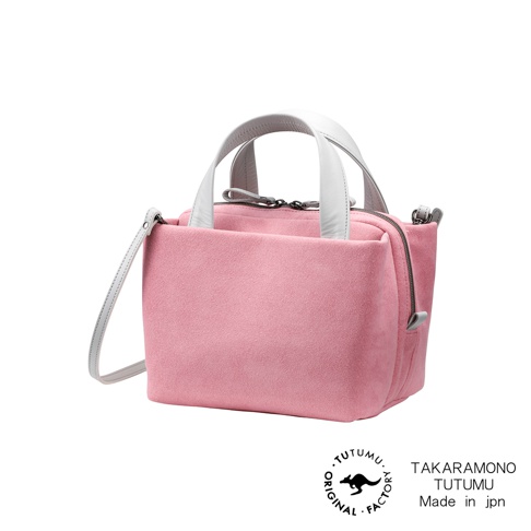 粉紅色麂皮 TUTUMU Suede tre tote 方形兩用托特包，配有白色皮革提把和可拆卸斜背包帶，包包正面中央有 TUTUMU 原廠標誌，右側有「TAKARAMONO TUTUMU Made in jpn」字樣。