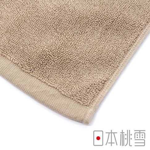 淺褐色毛圈浴墊，具有明顯的織紋和邊緣縫線。