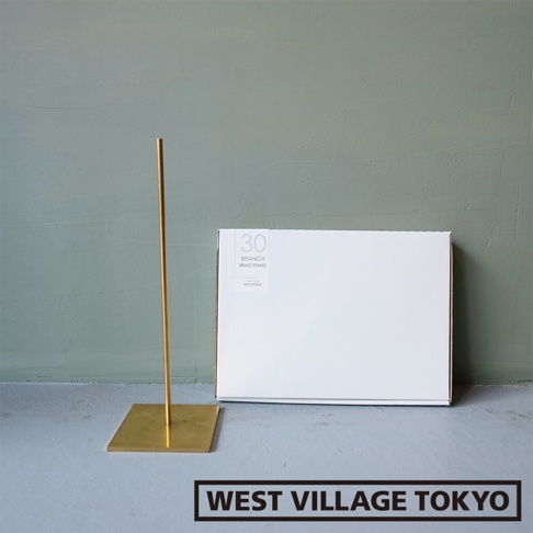 一個黃銅製的一輪花器/燈具展示架，高約30公分，具有方形底座和細長的支架，呈現金色光澤。旁邊有一個白色的產品包裝盒。