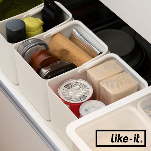 like-it 品牌標誌，圖片為抽屜內部，展示著不同大小的白色分隔收納盒，收納盒內裝有罐頭、紙巾、圓形木質容器及其他雜物