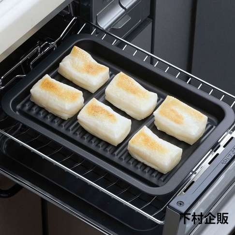 黑色波浪烤盤上擺放著六塊烤至金黃的米糕，烤盤置於烤箱的烤架上。