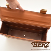 職人手作皮革兩用機師箱，展現棕色皮革材質與精緻縫線，內部空間清晰可見，搭配金色金屬扣環。