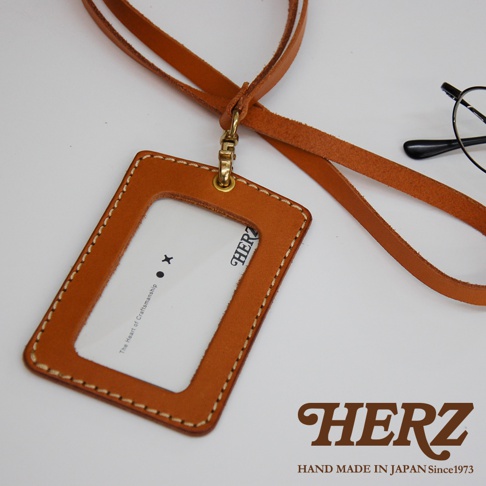 職人手作皮革直式證件識別夾，採用咖啡色皮革，附有同色系皮革掛繩及金色金屬扣環，質感精緻。