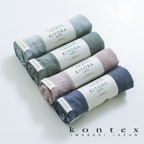 四條捲起的KONTEX品牌KIYORA MOKU系列毛巾由上至下依序排列，顏色分別為淺灰、綠色、粉色與深藍色。每條毛巾皆有印著品牌與產品名稱的紙質腰封，毛巾表面呈現細緻的紋理，整體以白色為背景，下方標示著KONTEX IMABARI JAPAN字樣。